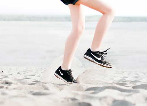 Woman wearing pair of black Nike running shoes
