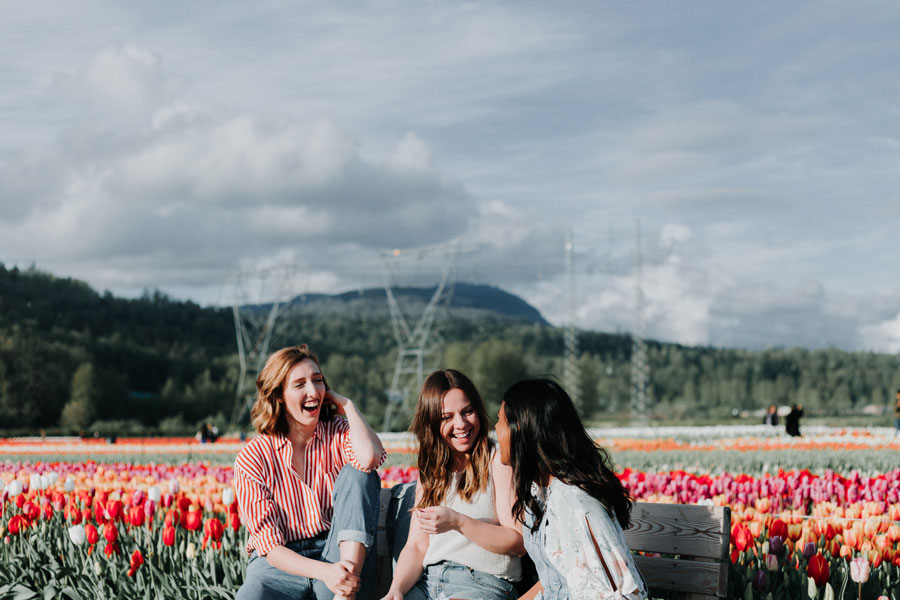 Image of three women sitting on a bench during summer depicting beautiful summer outfits for ladies