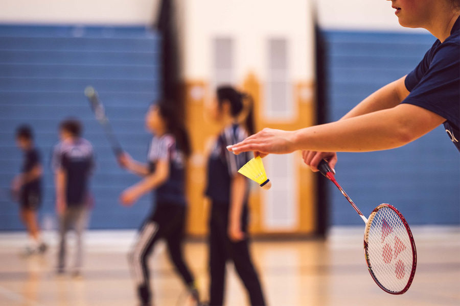 A badminton ready to hit the shuttlecock with the badminton racket, which are essential badminton equipment