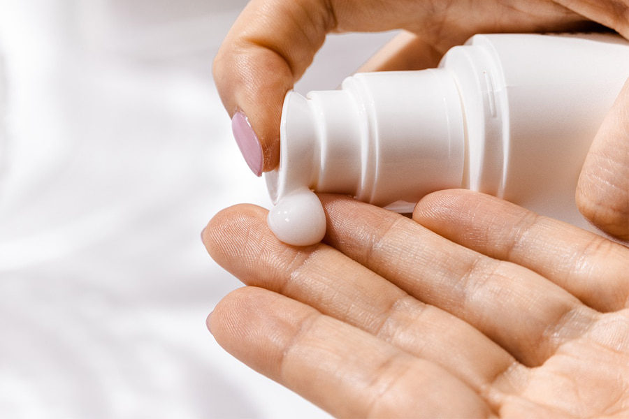 A body lotion squeezed to a hand denoting perfume types