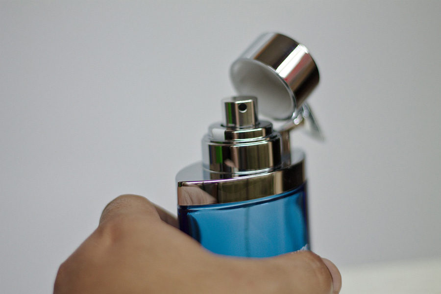 A bottle of perfume being opened representing the perfume brands for men
