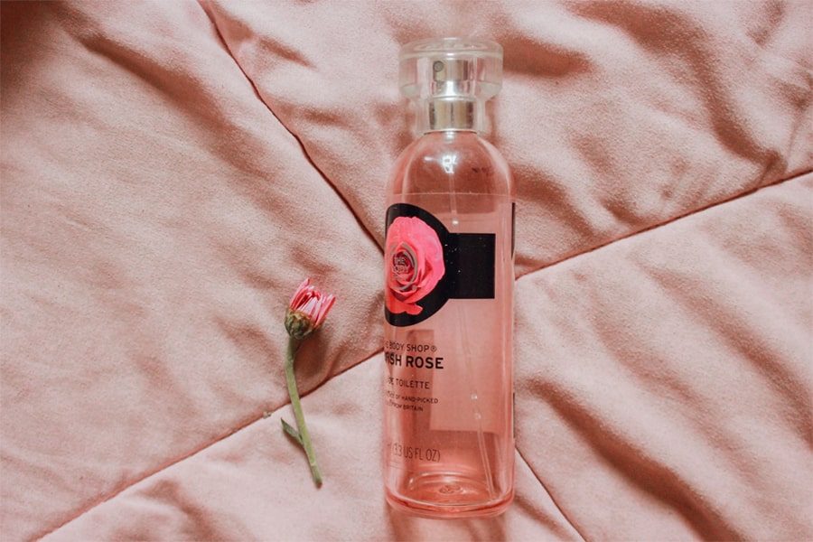 A perfume with rose fragrance alongside a rose denoting perfumes that smell like roses
