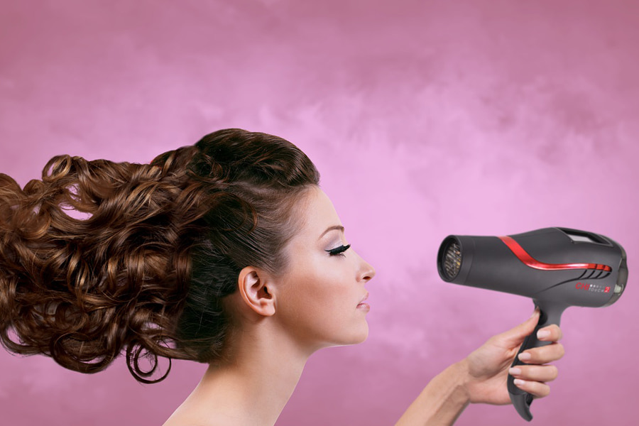 A woman using a hairdryer depicting best hairdryer to buy
