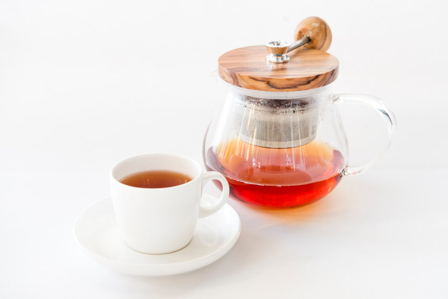 Image of a cup of freshly brewed rooibos tea with jug full of it depicting amazing benefits of rooibos tea