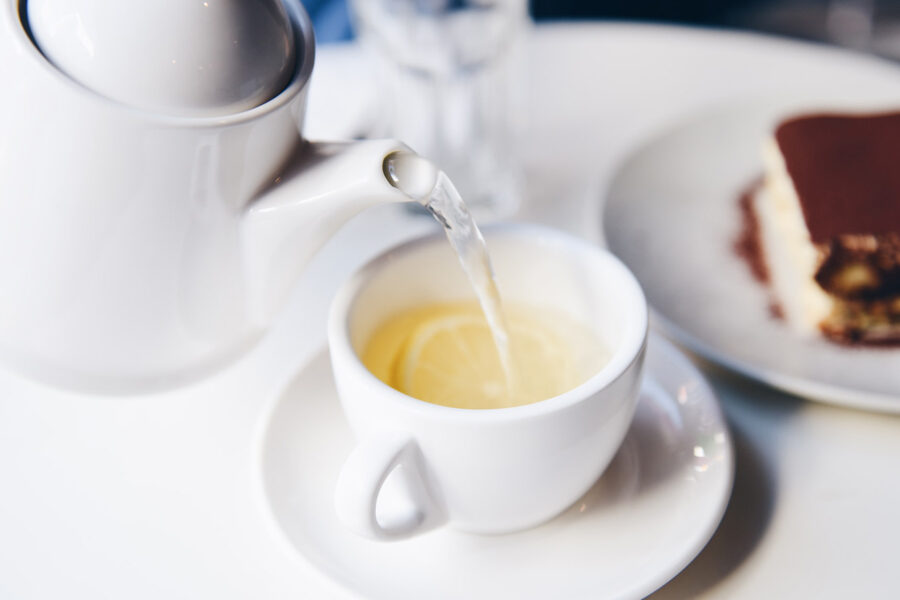 Image of white tea poured from a kettle depicting its benefits