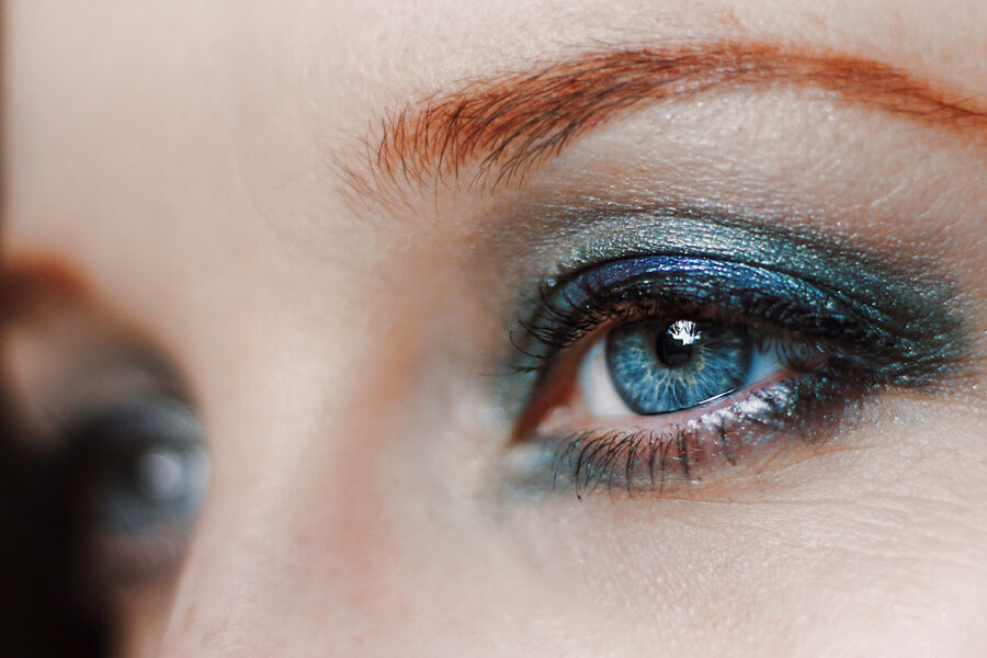 Image of a lady wearing mesmerizing blend of blue and green eyeshadow enhancing the beauty of her gaze
