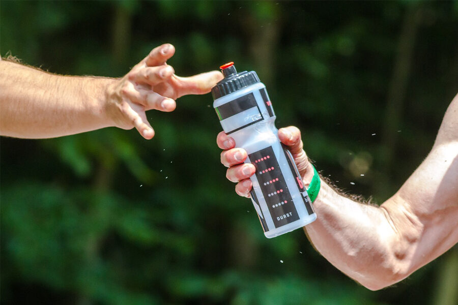 Image of two sports men sharing a sports water bottle